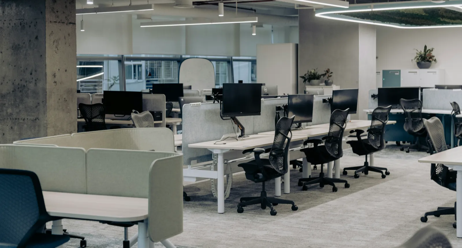 Empty open-plan office with rows of desks and chairs, ready for an evening clean